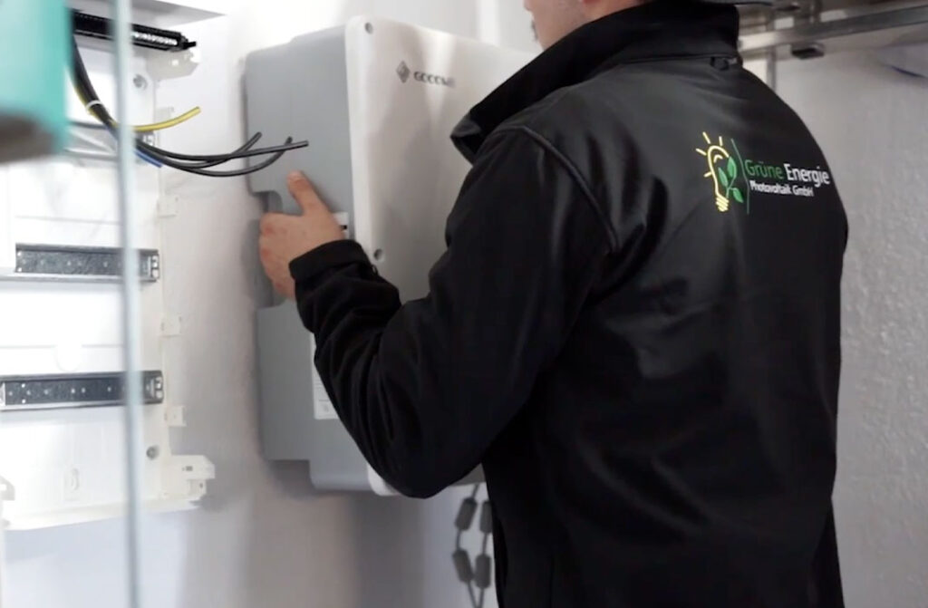 Handwerker der Grünen Energie hängt Wechselrichter auf